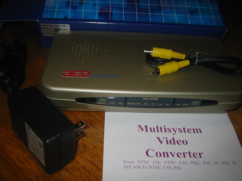 Picture of an AED Multisystem Video Converter, which can accept input signals encoded using any of the three major
analog video encoding standards (NTSC, SECAM, and PAL), and convert them to output signals encoded using either NTSC or PAL. It accepts North American 110V/60Hz current and even
has a North American plug.