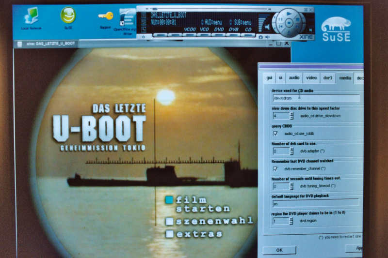 Screenshot of a Linux desktop showing the DVD playing software "xine" package displaying the title menu of a region
code 2 DVD of the film "Das letzte Boot" and the configuration dialog box where the user tells the software what region code the software should pass to the DVD drive.
